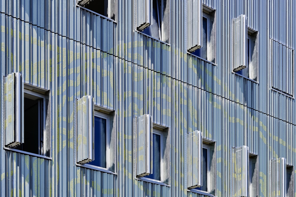 Façade en tôle perforée du centre de Ratisbonne, volets coulissants pliants ouverts devant les fenêtres