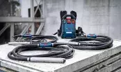 Unité d'alimentation dorsale Bosch et trois aiguilles vibrantes enroulées, posées sur une dalle de béton