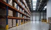 Vue intérieure d'un entrepôt logistique, racks de grande hauteur et allée de préparation de commandes.