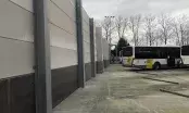 Bus électriques stationnés à côté de murs coupe-feu en béton cellulaire dans un dépôt sécurisé