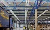 Plafond de hall industriel équipé de panneaux rayonnants et de luminaires linéaires intégrés, vu en contre-plongée.