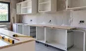 Cuisine en cours de montage, caissons bas sans façades, plan de travail posé en attente et mètre ruban