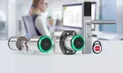 Cylindre électronique à anneau vert, béquille de porte connectée et badge porte-clés DOM-Metalux sur un plan clair