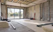 Ancien garage en cours de transformation, isolant posé au sol et aux murs, baie vitrée à la place de la porte