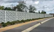 Mur anti bruit en béton préfabriqué à parement ondulé le long de la RD70, vu depuis la chaussée