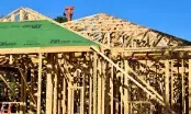 Chantier de construction d'une maison à ossature bois en Occitanie avec structure en bois apparente.