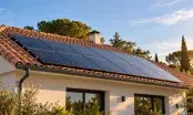 Panneaux photovoltaïques alignés sur le bas d'un versant de toiture en tuiles canal d'une maison de plain-pied