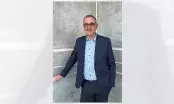 Maxime Julliot, nouveau Directeur Industriel du groupe Rector Lesage, en veste bleu marine devant un mur de béton