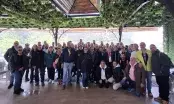 Groupe de concessionnaires réunis sous une pergola végétalisée lors d'une convention de réseau.