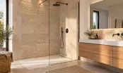 Douche à l'italienne à receveur affleurant et paroi fixe, mur en travertin, robinetterie noire et meuble en chêne