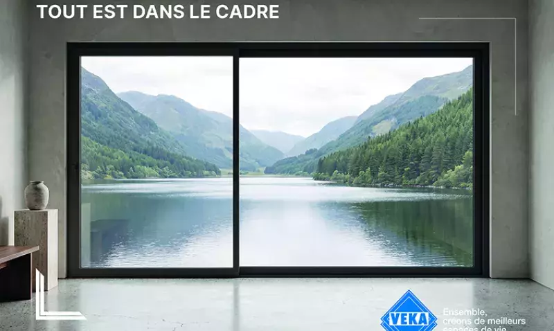 Baie coulissante VEKA ouvrant sur un lac de montagne, visuel de campagne présenté à Batimat 2026