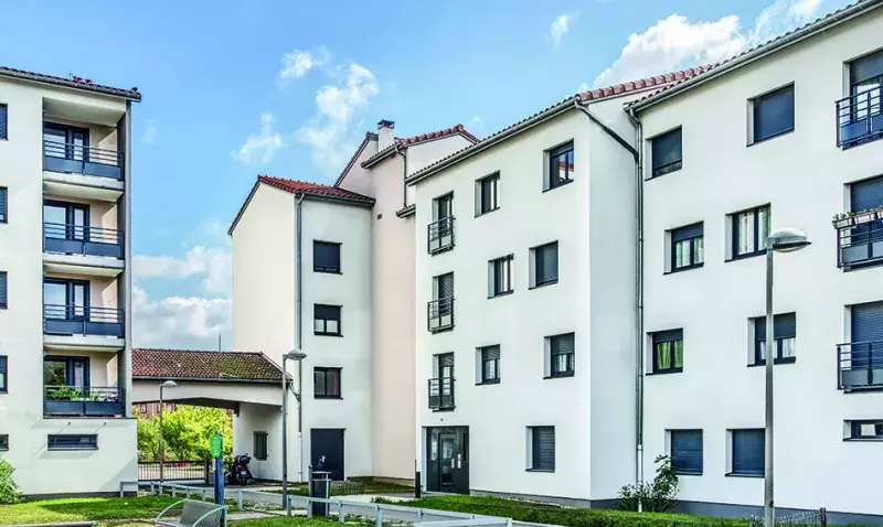 Façade blanche de deux immeubles de logements collectifs après isolation thermique par l'extérieur, par temps clair