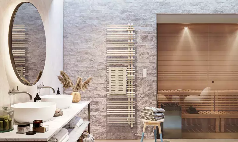 Radiateur design Manava installé dans une salle de bain moderne, servant de porte-serviettes