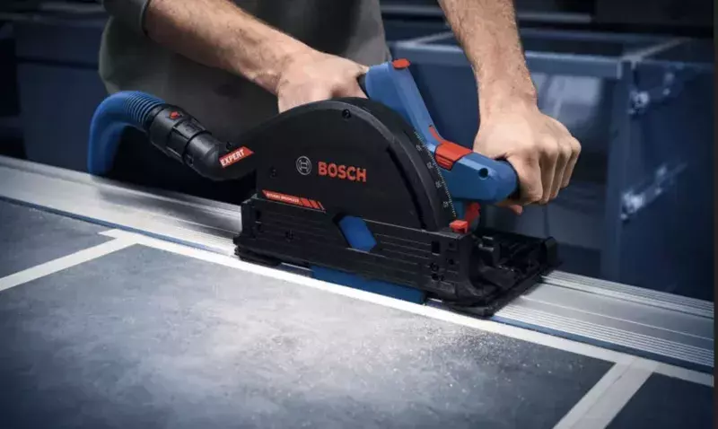 Scie plongeante sans fil Bosch compact posée sur un panneau de bois sur un chantier intérieur