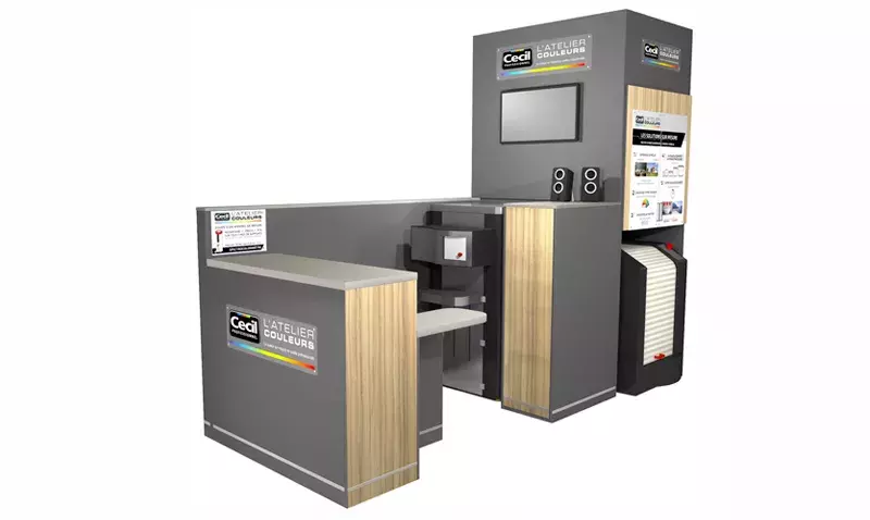 Un distributeur prépare une peinture personnalisée avec une machine à teinter en magasin.
