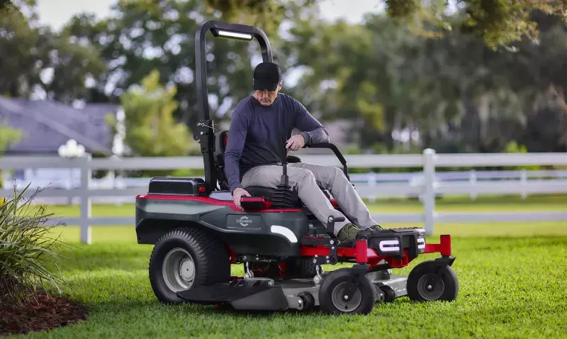 Tondeuse autoportée à batterie Cramer Zero-Turn verte, avec leviers de direction et écran LCD.