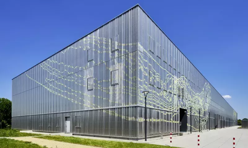 Vue d'angle du centre de conservation de Ratisbonne, façade en tôle ondulée perforée au motif jaune citron