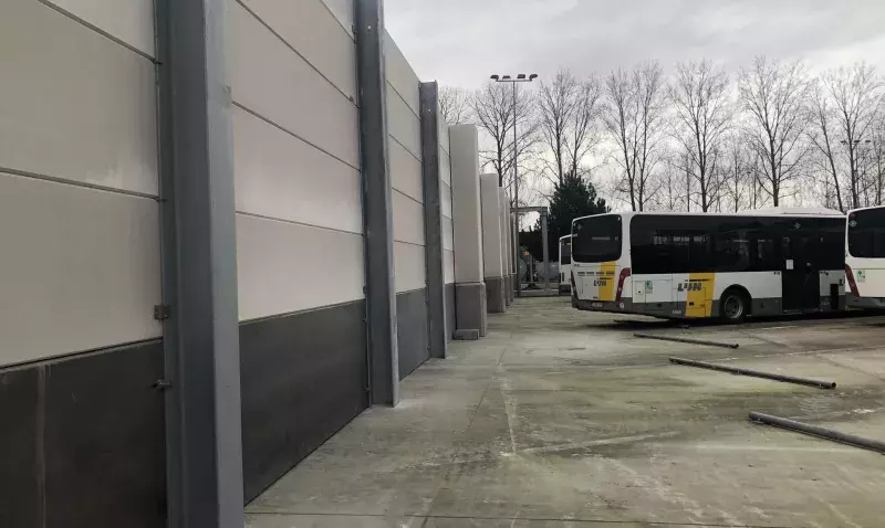 Bus électriques stationnés à côté de murs coupe-feu en béton cellulaire dans un dépôt sécurisé