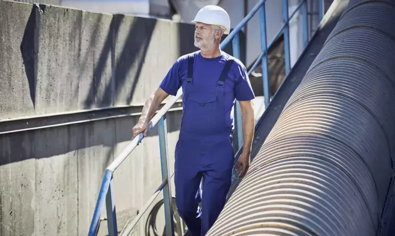 Ouvrier sur un chantier en été portant casque, vêtements techniques légers et gants respirants