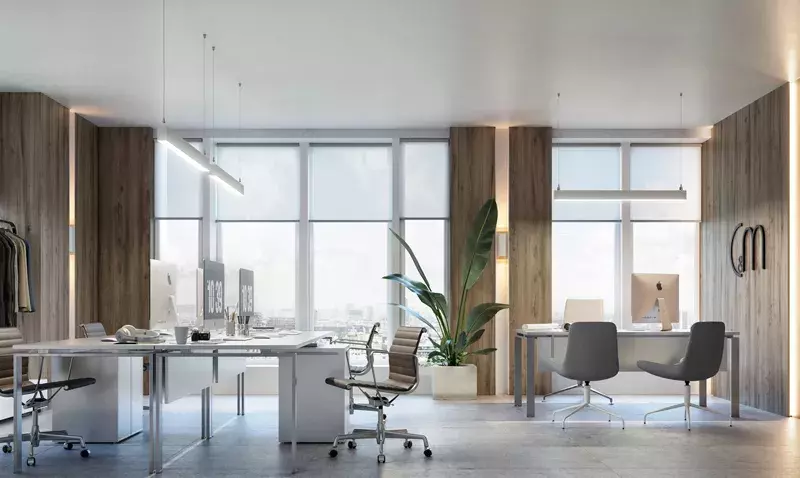 Bureau moderne avec deux luminaires linéaires suspendus, grandes baies vitrées et mobilier design.