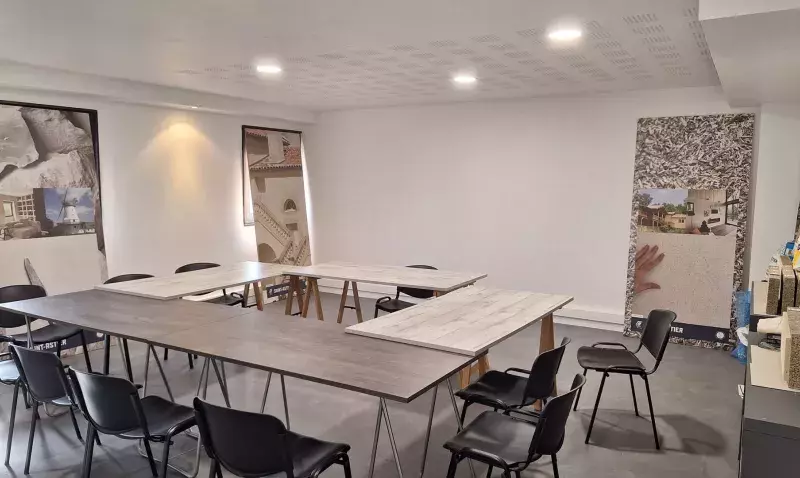 Salle de formation de Chaux Saint-Astier à Noisiel, tables disposées en U, chaises noires et kakemonos