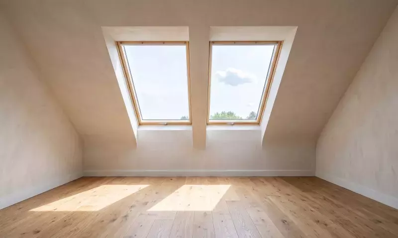 Combles aménagés éclairés par deux fenêtres de toit, rampants clairs et parquet chêne en pleine lumière