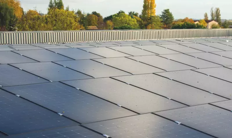 Toiture plate de bâtiment industriel entièrement couverte de modules photovoltaïques inclinés