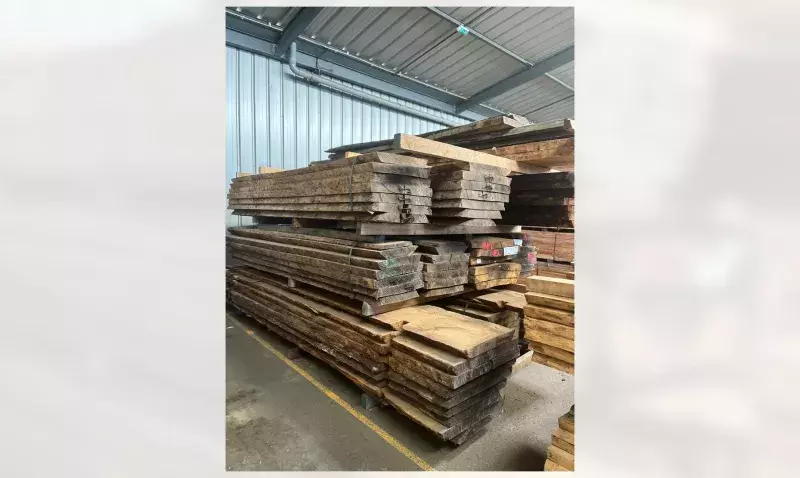 Piles de planches de chêne massif stockées dans l'atelier bois du site de Chartres