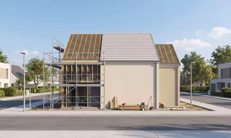 Maison individuelle en cours de rénovation, charpente à nu sur une travée, échafaudage en façade et couverture neuve
