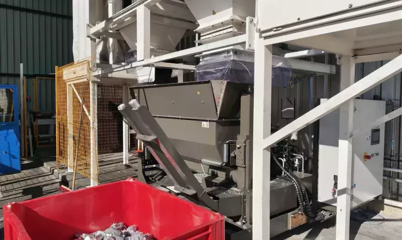 Compacteur de copeaux d’aluminium en service à Baillargues, bac de briquettes compactées au premier plan