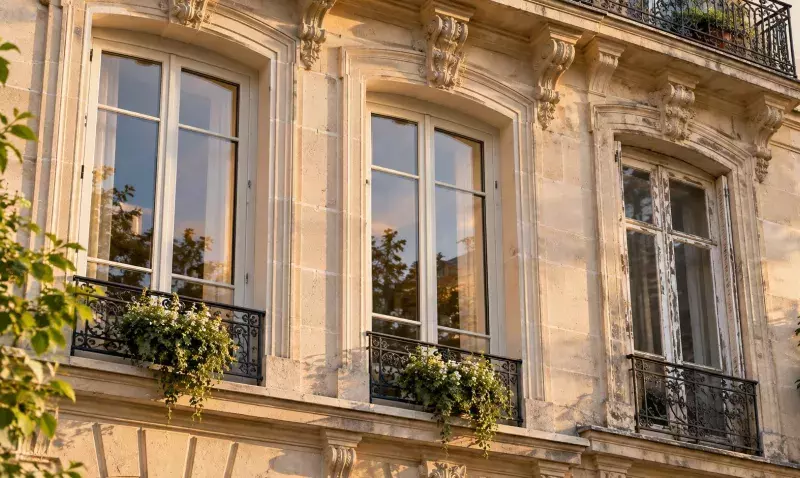 Façade en pierre de taille dont deux fenêtres à petits bois viennent d’être remplacées, la troisième restant ancienne