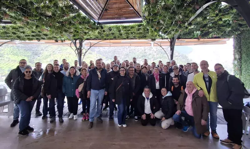 Groupe de concessionnaires réunis sous une pergola végétalisée lors d'une convention de réseau.