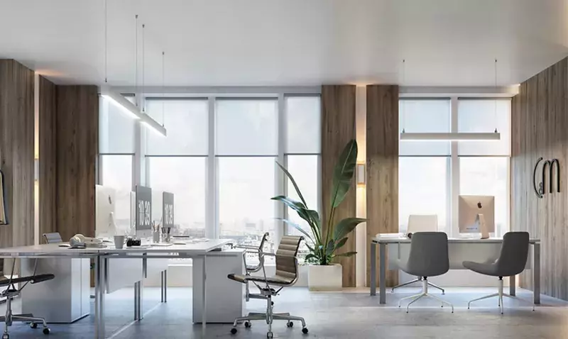 Bureau moderne avec deux luminaires linéaires suspendus, grandes baies vitrées et mobilier design.