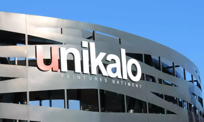 Façade métallique ajourée d'un bâtiment Unikalo portant l'enseigne de la marque sur fond de ciel bleu