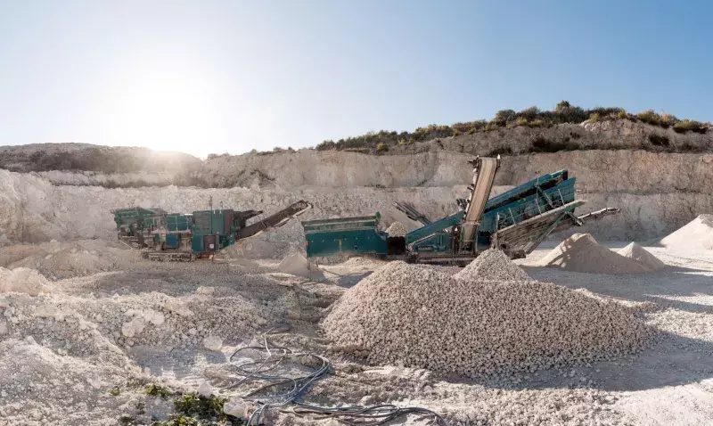 Chantier de construction avec engins, bâtiments en cours et matériaux à l'arrêt